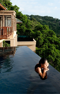 Villa de luxe avec piscine à débordement surplombant l'océan, femme se relaxant au bord
