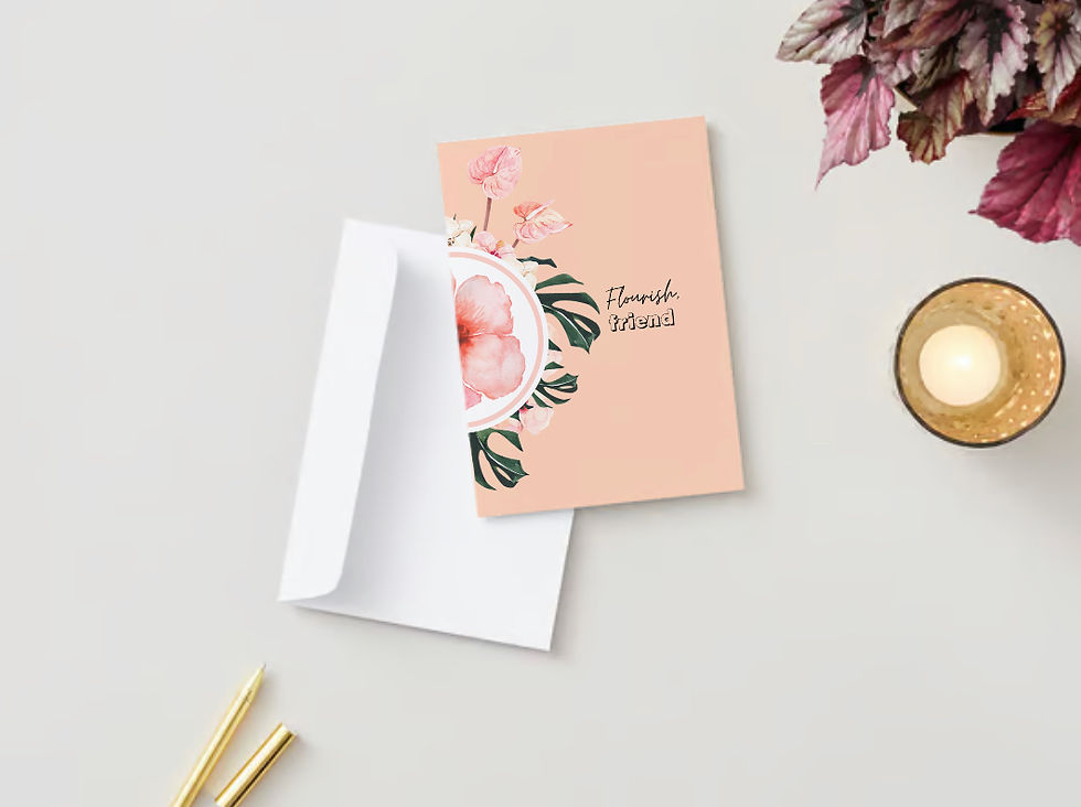 Greeting card with floral design. Text: "Flourish, friend." Beige background. Envelope, pencil, and candle on light surface, soft mood.