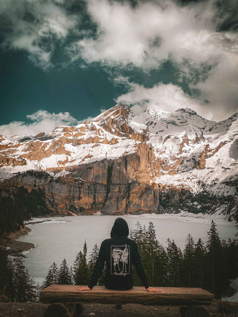 Travellingos Hoodie in Schwarz vor atemberaubender Aussicht beim Oeschinensee