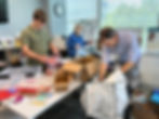 Roman Milian, Liz Brocato and Eric Kinne sort and pack supplies in the Educate Fairfax office.