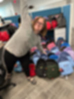 Volunteer Jessie Brocato stands before backpacks she helped pack for Educate Fairfax's School Supplies for Success campaign.