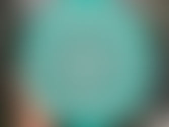 Close-up of a hand holding a circular, teal green canvas featuring a striking, symmetrical white dot mandala art design. This is a beautiful piece of handmade art and a perfect example of mandala wall art for home decor art.