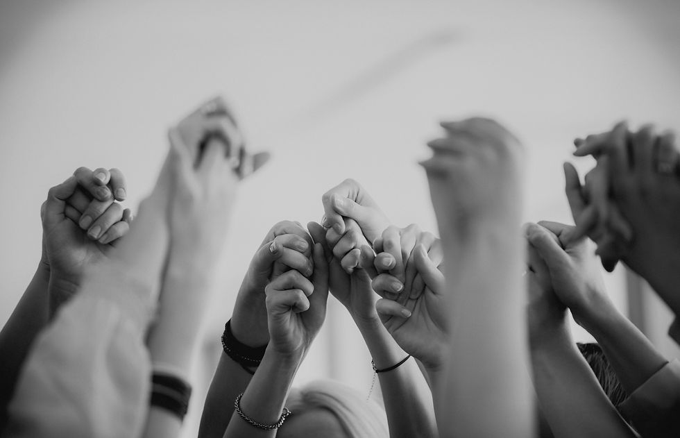 Hands gathered in a soft circle, symbolizing safety, shared humanity, and the emotional foundation of culture change.
