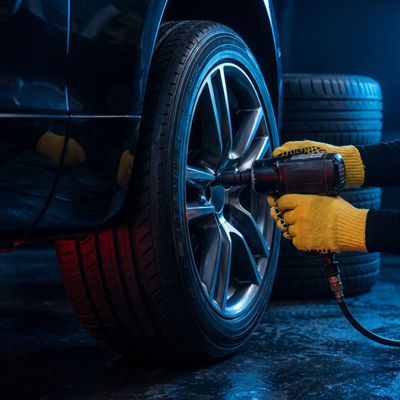 Mechanic servicing car wheel Tire & Wheel Service in garage with tools
