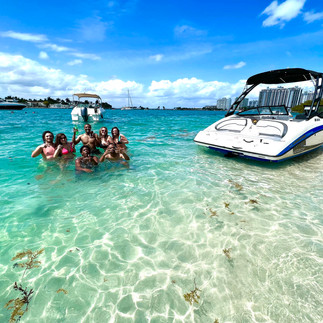 beautiful smiling people enjoying to the max their private boat tour in miami, they are in crystal clear waters at monument island and a boat to the side, best boat tours 2024 in miami, Miami Boat Rental