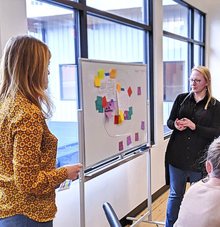 Kate working on a project board with a collegue