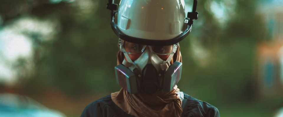 Person in hard hat, goggles, and respirator mask.