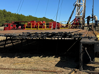 Metal pipes and workers in front of gas tower