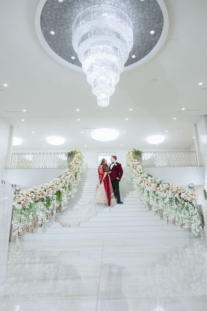 South Asian wedding couple on floral staircase