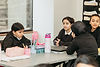 Girls from grades between 6 and 10 sharing a table while studing