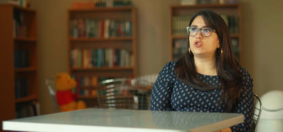 Woman with glasses speaking in a library