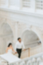 Happy couple walking up ornate white staircase