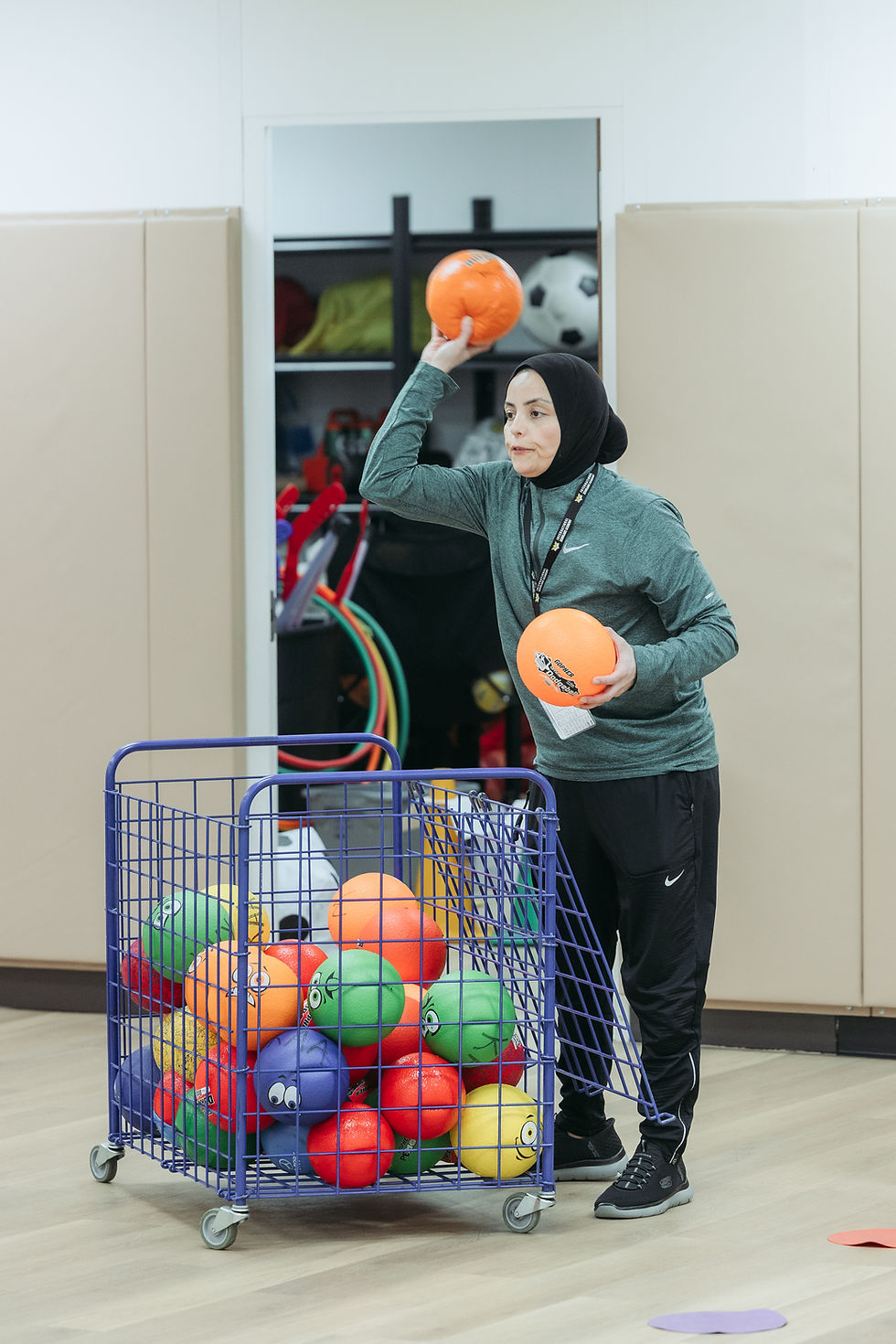 Coach throwing balls to students