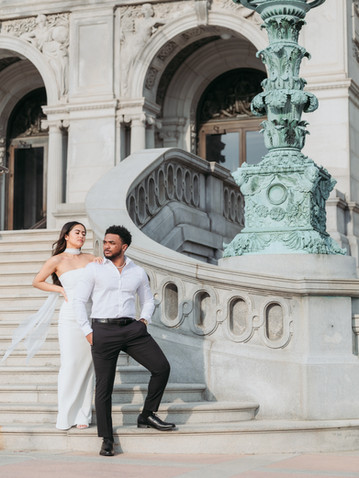 Elegant couple posing on ornate building stairs