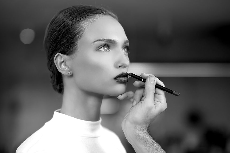 black and white image of a woman having lipstick applied for the article: The Art of Choosing: How Fashion and Beauty Become Acts of Resilience