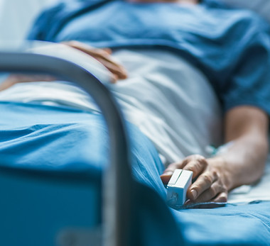 In the Hospital Sick Male Patient Sleeps on the Bed. Heart Rate Monitor Equipment is on Hi