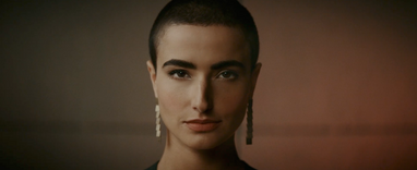 Closeup of a woman's face looking straight into the lens.