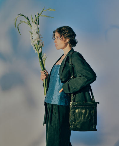 Woman in green suit holding flowers