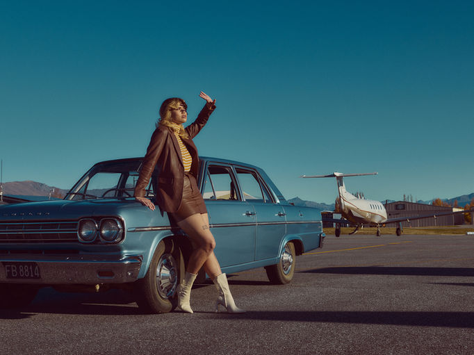 Girl resting against 50's car