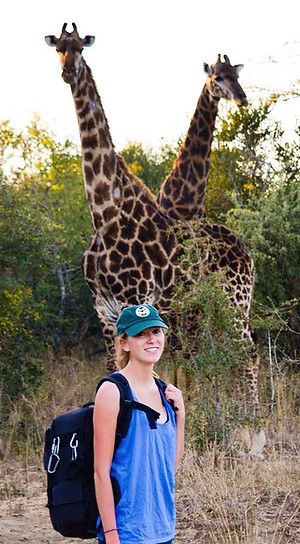 Kelsey Weir, photographer for Weir Picturesque, poses in front of two wild giraffes