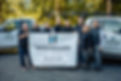 Highmark team in front of vehicles with company sign