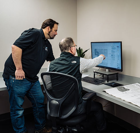 Highmark team looking at blueprint on computer