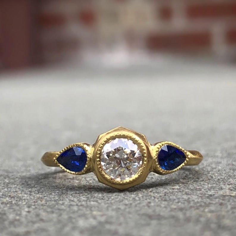 Thumbnail: Bespoke Pear-Shaped Sapphire and Old European Cut Diamond Ring in 18k Recycled Yellow Gold with Milgrain Detail and Knifeedge
