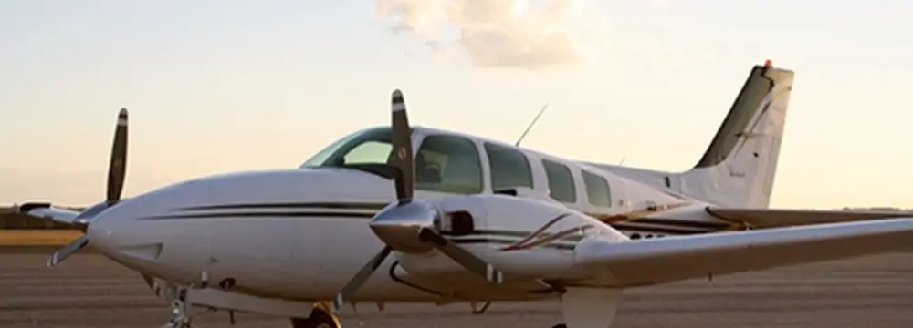 White twin-engine propeller aircraft on tarmac