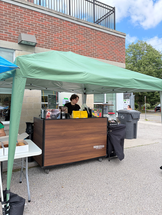 Outdoor coffee stand with a green canopy and wooden counter