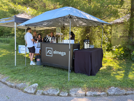 Almega outdoor event booth under a blue tent Canopy