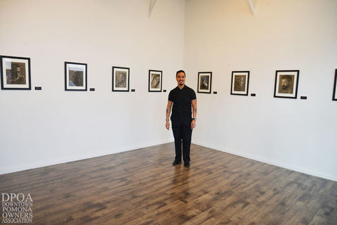 Man stands in gallery with framed photos ABOUT METRO in Downtown Pomona