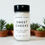Thumbnail: Bottle of body powder on counter with plants behind
