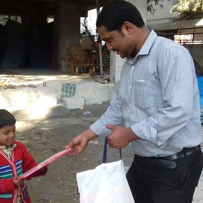 Sahu gives slates and crayons to kids of construction workers
