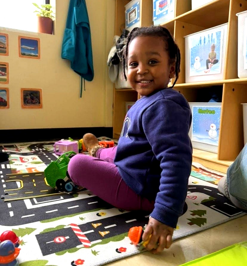 Happy child playing on a mat, supported by homeless family assistance