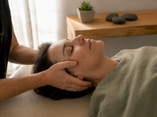 Therapist hands gently touching patient's head during CST session