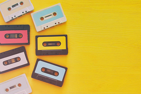 Two cassette tapes are lying on a yellow table