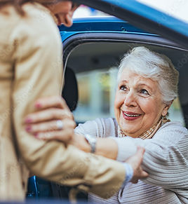 Older woman being helped out of the car