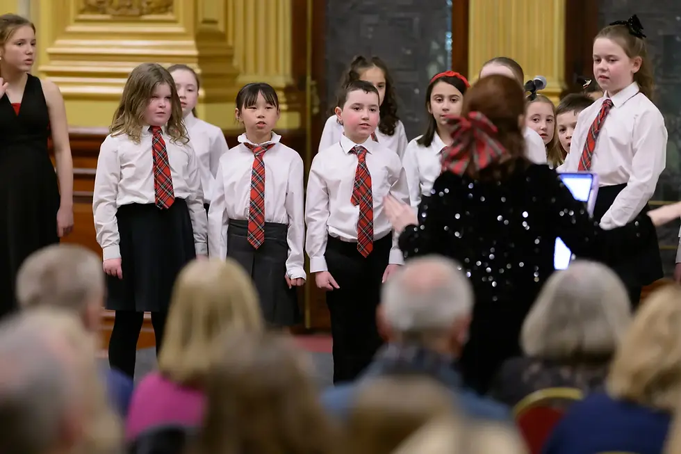 Fiona Clark conducting Junior Choir on stage in Glasgow City Chambers