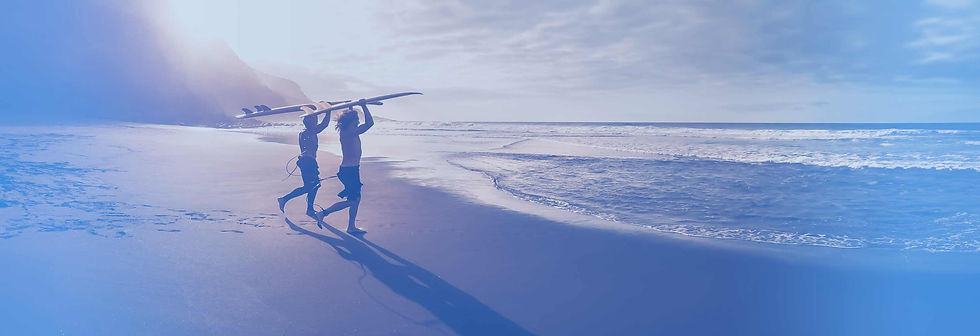 Two men running into an Australian beach with surfboards after obtaining an Australian Residency Visa.