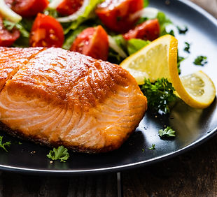 Fried salmon steaks with vegetables on wooden table.jpg
