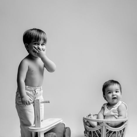 Séance photo famille en studio à Bonnut (Landes), portrait en noir et blanc d’enfants en bas âge dans une mise en scène minimaliste.
