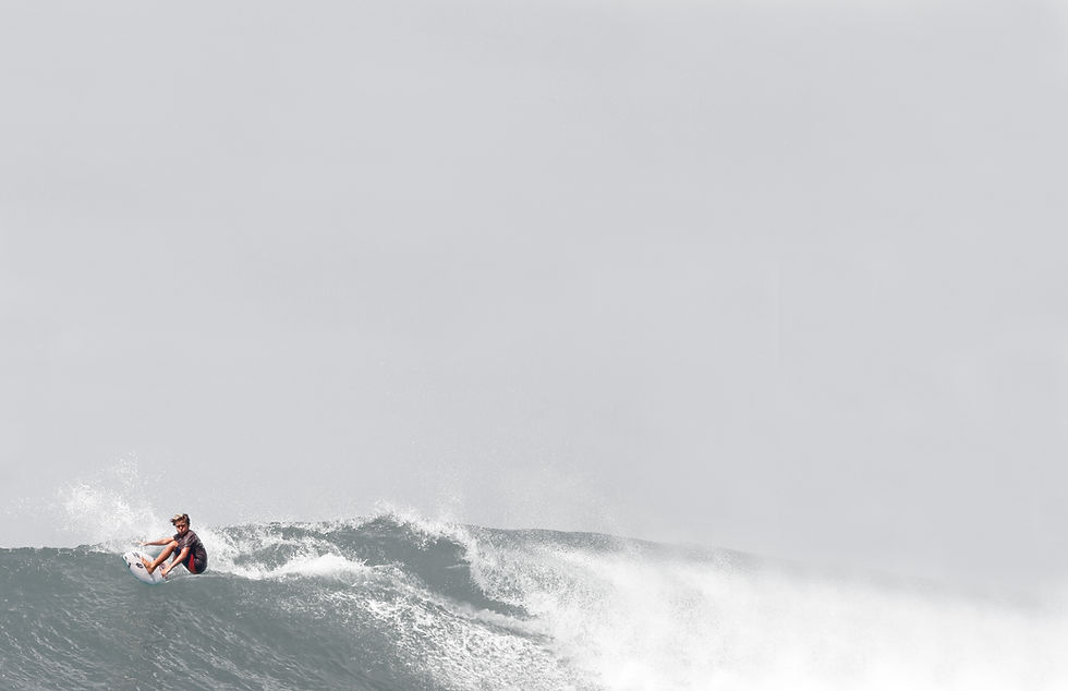 A young surfer catches a wave at Mount Irvine beach in Tobago