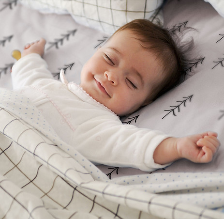 Bébé dormant dans son lit avec un sourire