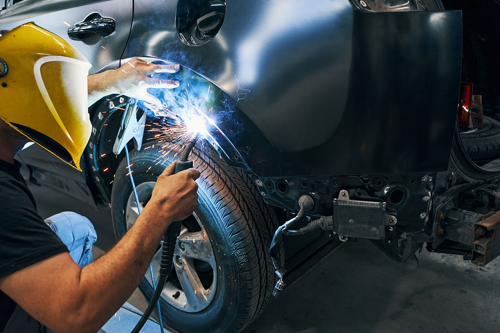 Ein Mitarbeiter von Carrosserie Bänziger beim Schweissen eines Carrosserieteiles.