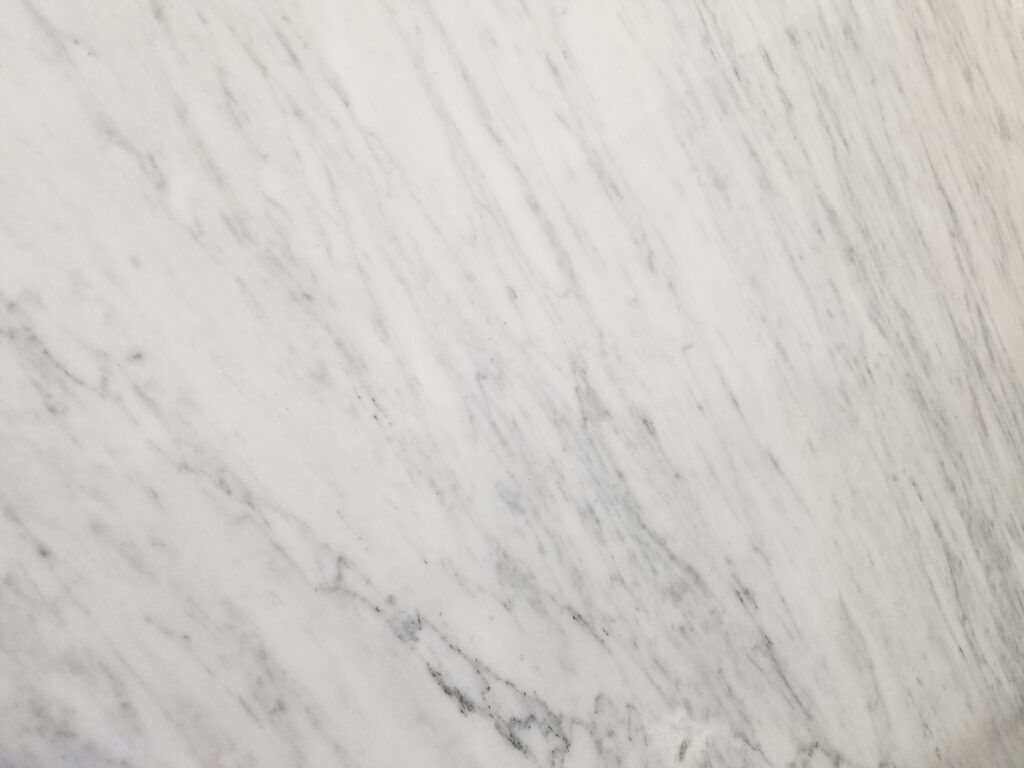 White Carrara Marble with light grey veining, elegant stone surface background