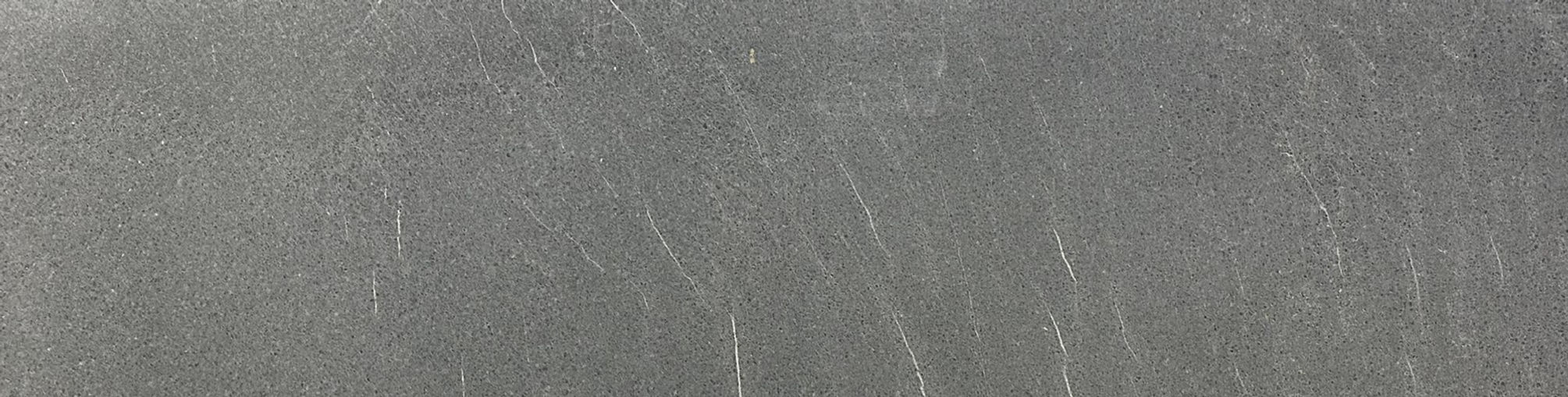 Abstract gray surface with subtle lines and textures, creating a visual effect.