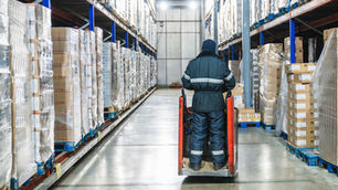 A man on a piece of machinery in a cold storage facility.