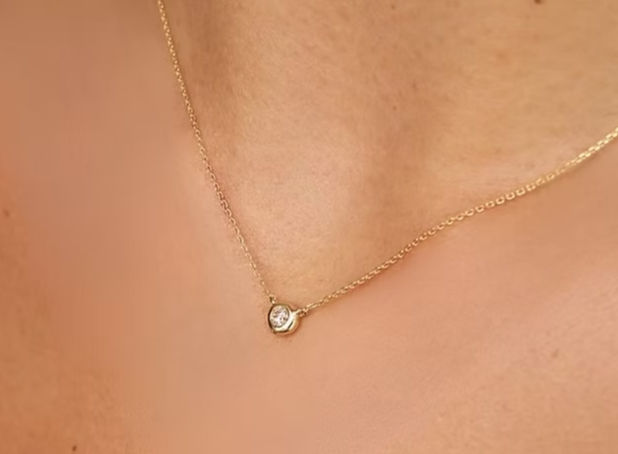 A woman wearing the Illuminess™ ‘Light Inside Her’ Single Stone Necklace