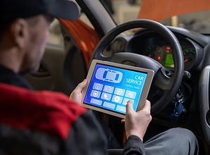 Close up of car mechanic using digital tablet with service and maintenance app on screen w