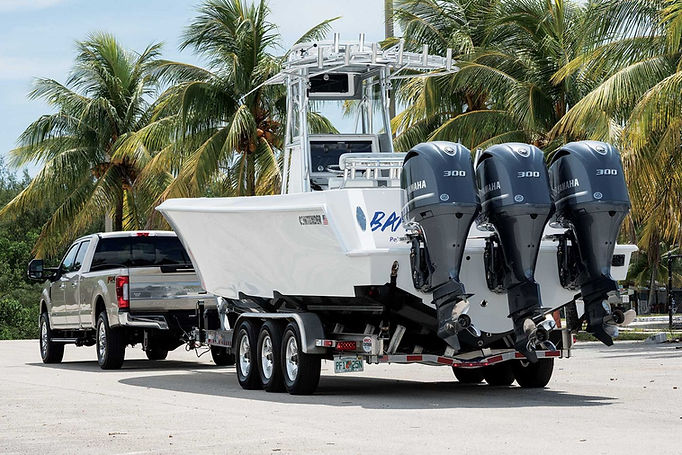 truck towing a new white boat with 3 outboard engines on a Boat Trailer that is a Rental